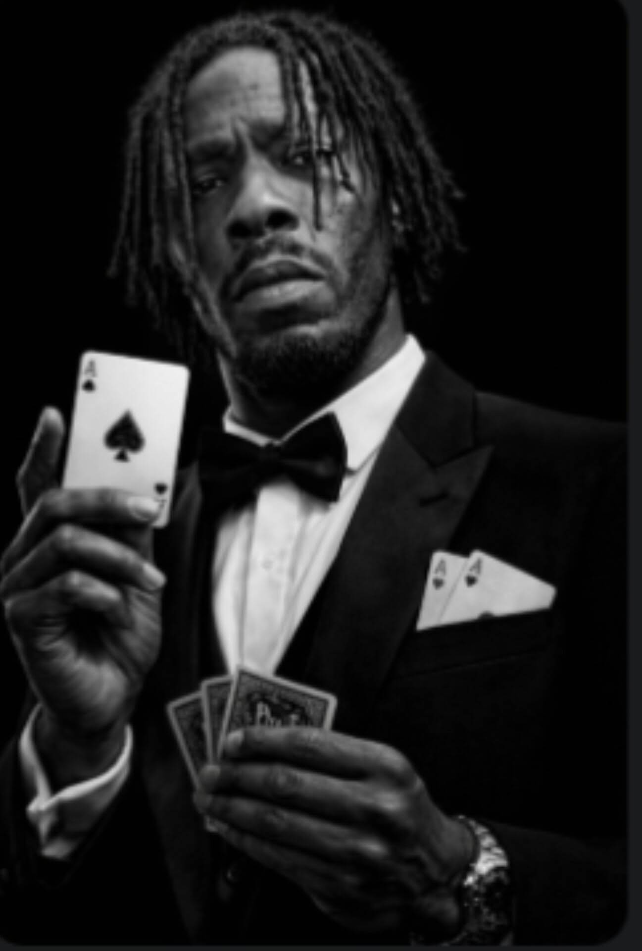 Black and white studio portrait of MINDBENDA in a tuxedo